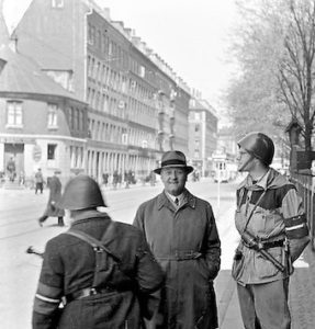 En 'kanonfotograf' tog dette billede af Erik Smith den 5. maj, 1945. Modstandsmanden til venstre med ryggen til er elektriker-lærling Ebbe Madsen. Den smilende mand er ukendt.